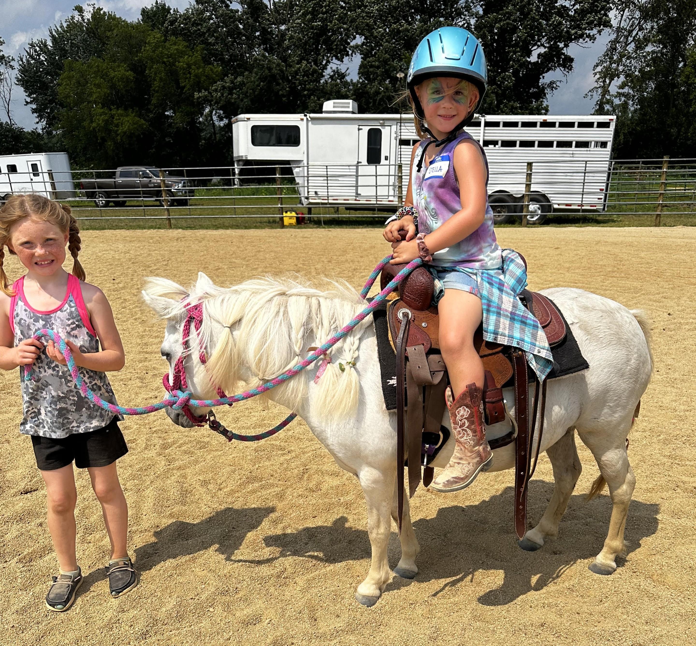 A group of kids gathered around a pony at a party