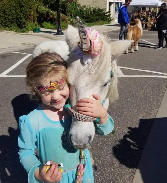A child with a unicorn-styled pony at a Pony Parties Express party