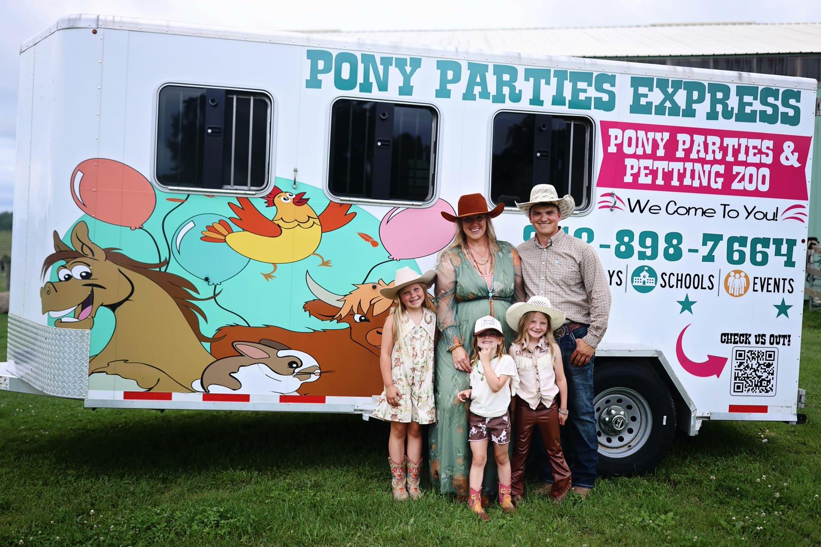 A family of five stands in front of a trailer painted with Pony Parties Express and Pony Parties & Petting Zoo branding.